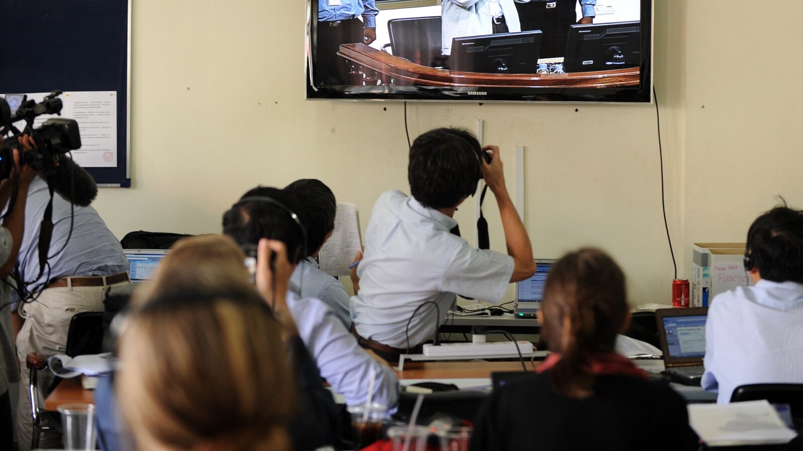 FILE - Cambodian and foreign journalists watch a live-feed video in a press room at the Extraordinary Chamber in the Courts of Cambodia, in Phnom Penh, Feb. 3, 2012. 