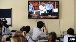 Para wartawan Kamboja dan reporter asing menonton video konferensi pers di ruangan media di Pengadilan Luar Biasa Kamboja yang terletak di Phnom Penh, pada 3 Februari 2012. (Foto: AFP/Tang Chhin Sothy)