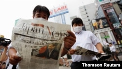 Men read extra editions of a newspaper reporting Japanese Chief Cabinet Secretary Yoshihide Suga won in a ruling party leadership election paving the way for him to replace Prime Minister Shinzo Abe in Tokyo, Sep. 14, 2020.