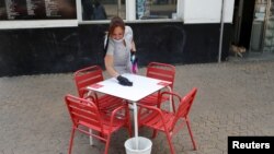 Una imagen que ilustra el alivio de los confinamientos en España. Una camarera limpia una mesa solitaria de un restaurante en Sevilla el 11 de mayo de 2020.