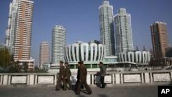 North Koreans walk past Ryomyong Street, the newest residential development in Pyongyang, North Korea, April 11, 2017. North Korea will mark the 105th anniversary of the birth of late leader Kim Il Sung on April 15.