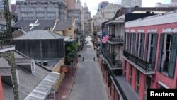 FILE - The normally bustling tourist mecca of Bourbon Street lies deserted in the early afternoon during shelter in place orders to slow the spread of the coronavirus, in New Orleans, Louisiana, March 27, 2020.