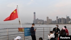 Passengers ride a ferry on the Yangtze River after travel restrictions to leave Wuhan, the capital of Hubei province and China's epicenter of the COVID-19 outbreak, were lifted, April 8, 2020.