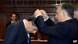 Bulgarian President Rosen Plevneliev, left, is awarded with the Grand Cross of the Hungarian Order of Merit with Chain and Star with Golden Beams by Hungarian Prime Minister Viktor Orban in the Parliament building in Budapest, Hungary, Nov. 10, 2016. 