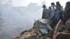 Nepalese rescue workers and civilians gather around the wreckage of a passenger plane that crashed in Pokhara, Nepal, Jan. 15, 2023. 