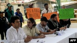 Miembros de comunidades locales levantan carteles en demanda de acuerdos de cese al fuego en las negociaciones de paz entre el gobierno de Colombia y facciones disidentes de las FARC en el departamento del Cauca.