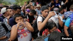 Honduran migrants, part of a caravan trying to reach the U.S., drink water after arriving to the border between Honduras and Guatemala, in Agua Caliente, Guatemala, Oct. 15, 2018.