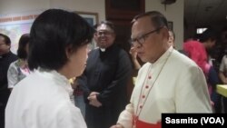 Uskup KAJ Ignatius Kardinal Suharyo berjabat tangan dengan salah satu hadirin pada perayaan Natal di Gereja Katedral, Jakarta, Rabu, 25 Desember 2019. Foto: Sasmito