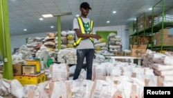 FILE —A volunteer counts stock of food items in the Lagos Food Bank warehouse in Lagos, Nigeria, March 23, 2024.