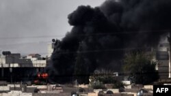 A picture taken in the southeastern Turkish village of Mursitpinar, Oct.10, 2014, shows smoke rising from the Syrian town of Ain al-Arab, known to Kurds as Kobane, after US-led coalition airstrikes.