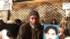 FILE - Mohammad Bilal holds a picture of his son Hazratullah as he takes part in a protest with members of the Pashtun community against what they say are enforced “disappearances” and routine oppression, in Islamabad, Feb. 8, 2018. 