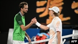 Russia's Daniil Medvedev (L) greets Finland's Emil Ruusuvuori after victory in their men's singles match on day five of the Australian Open tennis tournament in Melbourne early on January 19, 2024.