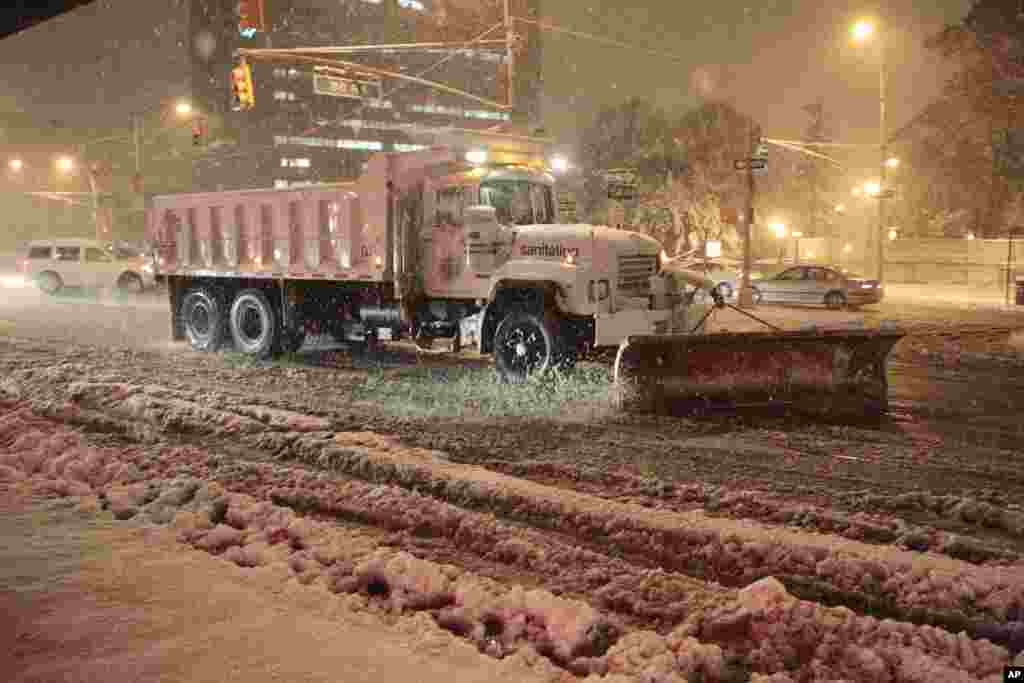 Workers shovel snow from Queens Blvd. during a snow storm, November 7, 2012, in New York.