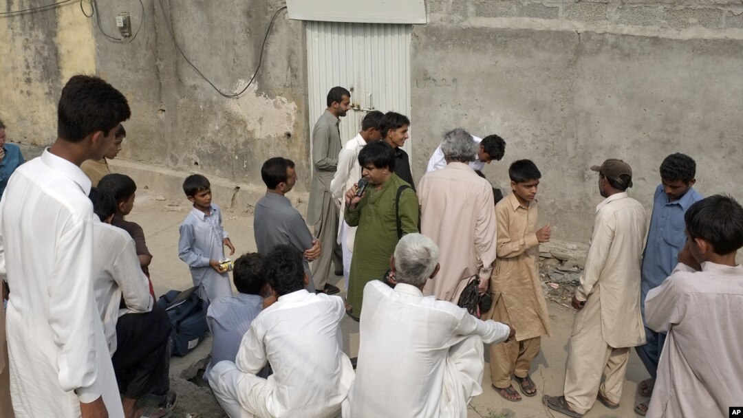 Warga Pakistan berkumpul di luar rumah anak perempuan yang dituduh menghina agama di pinggiran Islamabad (20/8). 