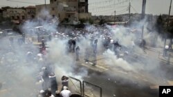 Des Palestiniens tentant d'échapper aux gaz lacrymogènes des forces israéliennes, Jérusalem, le 21 juillet 2017. 