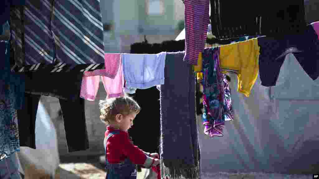 Un enfant réfugié kurde syrienne de la région de Kobané tient un linge dans un camp de Suruc, le 12 novembre 2014.