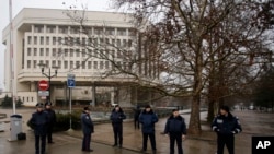 Polisi Ukraina berjaga-jaga di depan gedung pemerintah di Simferopol, Krimea, Ukraina (27/2).. (AP/Darko Vojinovic)