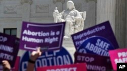 FILE - People hold up signs in favor of legal abortion during a protest against abortion bans, May 21, 2019, outside the Supreme Court in Washington.