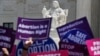 FILE - People hold up signs in favor of legal abortion during a protest against abortion bans, May 21, 2019, outside the Supreme Court in Washington.