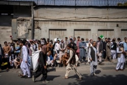 Afghans line up outside the Iranian Embassy to request travel visas in Kabul, Afghanistan, Sept. 29, 2021.