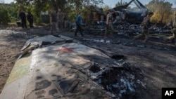 Ukrainian servicemen examine fragments of a Russian military plane that was shot down on the outskirts of Kostyantynivka, a near-front line city in the Donetsk region, Ukraine, Oct. 5, 2024.