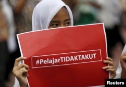 Một học sinh tiểu học cầm biển ghi "Học sinh không sợ hãi" trong một cuộc mít-ting nhỏ chống khủng bố, 1 ngày sau vụ tấn công bằng bom và súng ở Jakarta, ngày 15/1/2016.