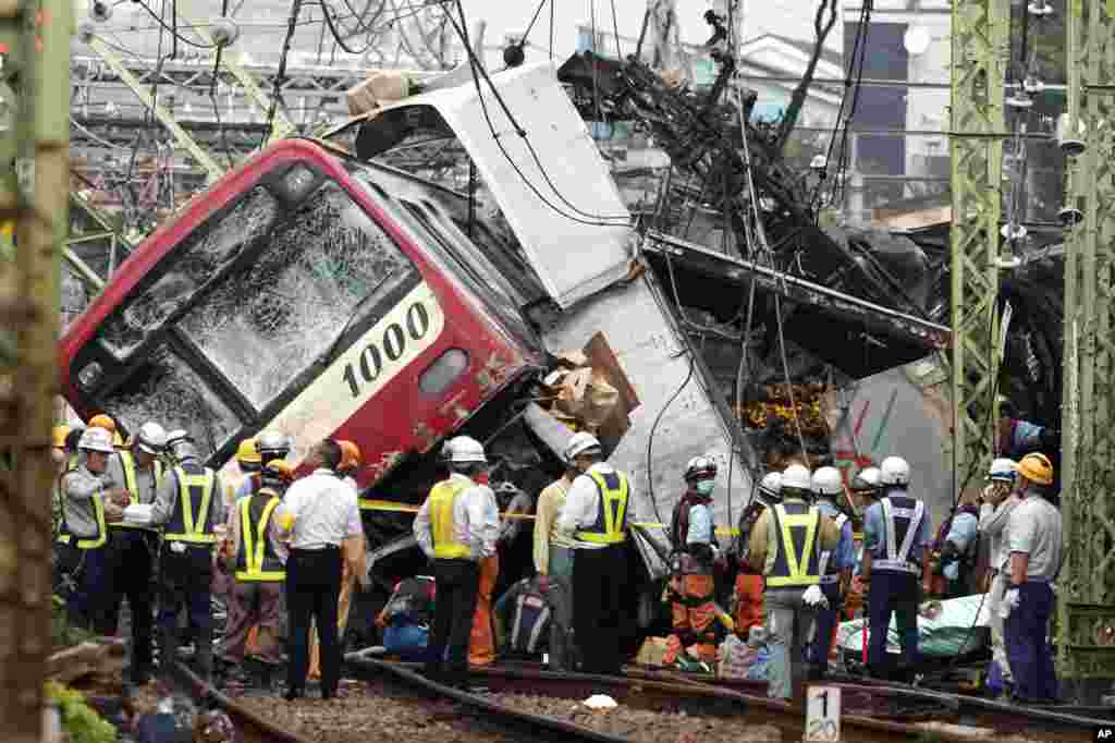 The Keikyu express train sits derailed after its collision with a truck in Yokohama, south of Tokyo, Japan. The commuter train and a truck loaded with boxes of citrus collided at a rail crossing near Tokyo, injuring dozens of people, authorities said.