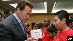 Former California Gov. Arnold Schwarzenegger shows a first aid kit to students in this 2006 file photo.