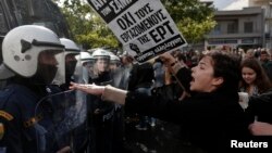 A protester yells at policemen outside the headquarters of Greece's state television ERT, north of Athens, November 7, 2013. 
