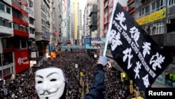 资料照：香港民众打着“光复香港、时代革命”的旗帜参与反政府示威（路透社2019年12月8日）