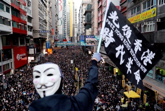 资料照：香港民众打着“光复香港、时代革命”的旗帜参与反政府示威（路透社2019年12月8日）