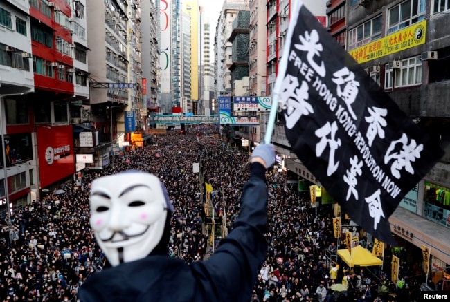 资料照：香港民众打着“光复香港、时代革命”的旗帜参与反政府示威（路透社2019年12月8日）