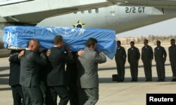 FILE - The crew of a Brazilian military plane stands at attention as the coffin with the body of the U.N. special envoy to Iraq, Sergio Vieira de Mello is put on the plane at the airport in Baghdad, Aug. 22, 2003.