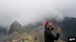 Un turista posa frente al sitio arqueológico Machu Picchu en Cusco, Perú, el 2 de noviembre de 2020.