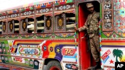 A Pakistani soldier stands guard in a bus carrying election staff and polling related material to stations in Karachi, Pakistan, July 24, 2018.