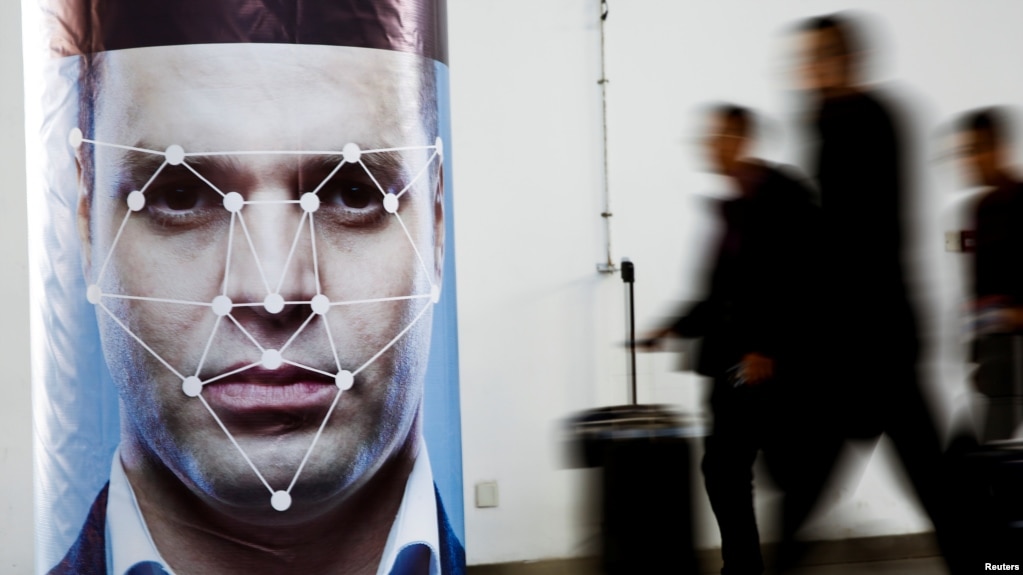 路透社资料照：人们在参观北京举行的一个公安科技产品展览会上走过人脸识别技术的展台。（2018年10月24日）(photo:VOA)