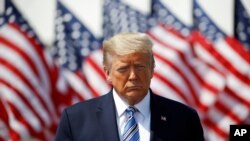 President Donald Trump listens as Defense Secretary Mark Esper speaks in front of the U.S. Navy hospital ship USNS Comfort at Naval Station Norfolk in Norfolk, Va., March 28, 2020. 