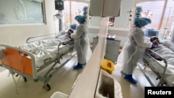 FILE: A medical staff is reflected in a mirror as she attends to a COVID-19 patient at a special ward at Arwyp Medical Centre.