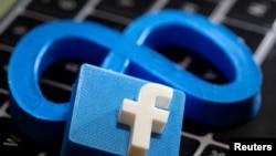 FILE PHOTO: A 3D printed Facebook's new rebrand logo Meta and Facebook logo are placed on laptop keyboard in this illustration