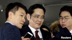 FILE - Jay Y. Lee (center) vice chairman of Samsung Electronics, arrives to be questioned as a suspect in bribery case in the influence-peddling scandal that led to the president's impeachment at the office of the independent counsel in Seoul, South Korea.