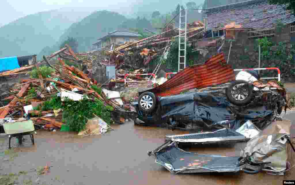 A destroyed car lies near collapsed houses after a landslide caused by heavy rains in Minamiaso town, Kumamoto prefecture.