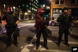La policía de Portland monta guardia el 29 de agosto de 2020 en Portland, Oregon. Una persona fue asesinada a tiros el sábado por la noche en Portland cuando una caravana de partidarios del presidente Donald Trump y Black Lives Matter se enfrentaron.