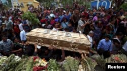 People hold the casket of Maria Magdalena Zelada, who died during the eruption of the Fuego volcano, during her funeral in Alotenango, Guatemala, June 8, 2018. 