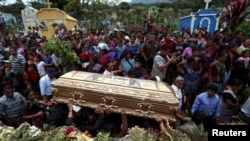 Des gens tiennent le cercueil de Maria Magdalena Zelada, morte lors de l'éruption du volcan Fuego, lors de ses funérailles à Alotenango, au Guatemala, le 8 juin 2018.