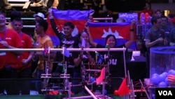 Members of the Cambodian robotics team raise their national flags to celebrate after winning their first competition during the First Global Challenge robotics competition in Washington, DC, Sunday, July 17, 2017. (Nem Sopheakpanha/VOA Khmer) 