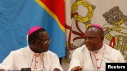 Mgr Marcel Utembi, à gauche, président de la Conférence épiscopale nationale du Congo (Cenco) et Mgr Fridolin Ambongo discutent lors du dialogue qu’ils président à Kinshasa, RDC, 21 décembre 2102.