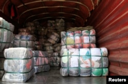 Bales of secondhand clothing waiting to be off-loaded from a truck at the busy the Gikomba market in Nairobi, Sept. 18, 2014.