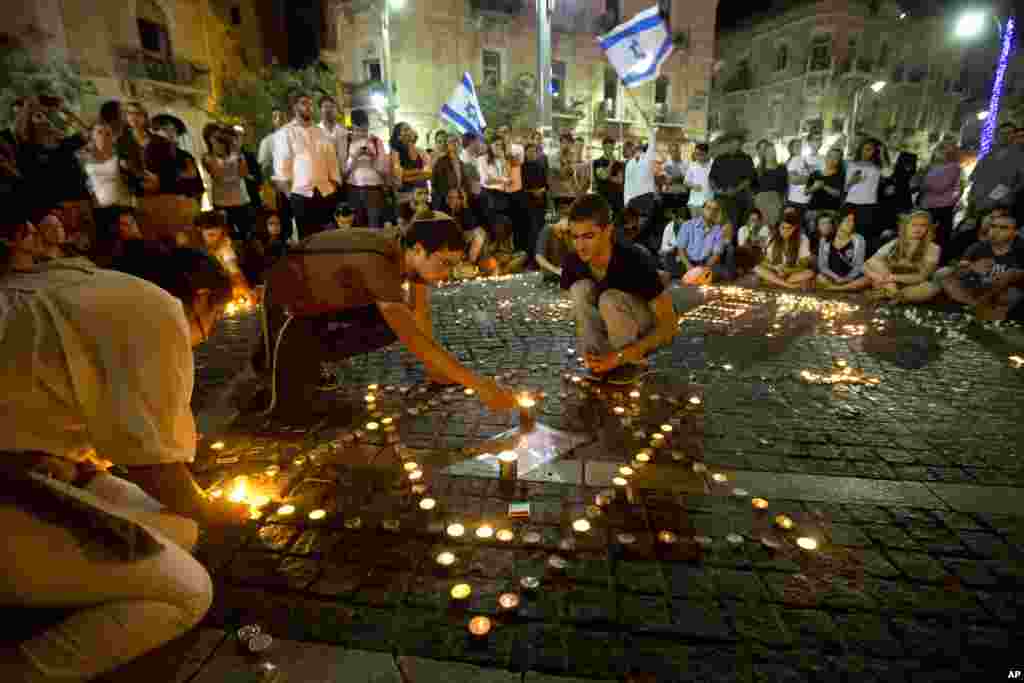 Israelis light candles as they gather in Jerusalem after the announcement that the bodies of the three missing teenagers were found near the West Bank town of Hebron, June 30, 2014. 