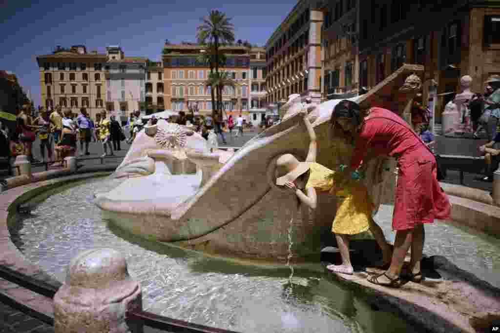 People drink from Italian 17th Century sculptor Bernini&#39;s Barcaccia fountain, in Rome. City hall announced that Mayor Virginia Raggi had signed an ordinance aimed at protecting some 40 fountains of historic or artistic interest to try to protect the monumental works, not infrequently trashed by tourists, sports fans and Romans.