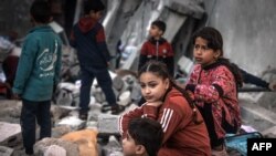 FILE - Children sit amid the rubble of destroyed buildings following Israeli bombardment in Rafah on the southern Gaza Strip on December 29, 2023, amid the ongoing battles between Israel and the Palestinian militant group Hamas. 